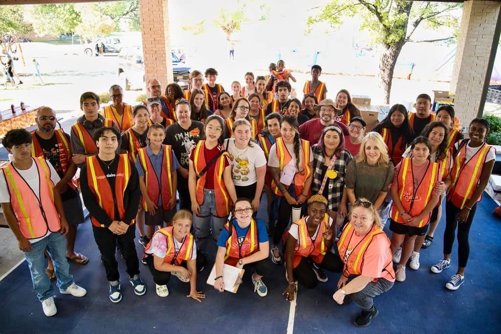 Festival volunteers in vests, one with a clipboard, ready for their posts.
